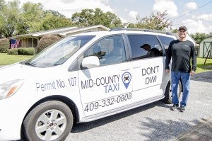 Mike Tarver, 64, poses with one of his Mid-County Taxi vans outside his Nederland home Friday morning.