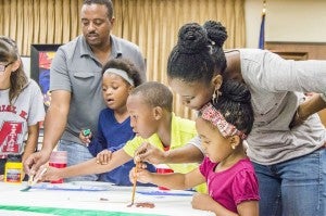 Artist Ted Ellis, left, leads Port Arthur students in creating a three-piece mural Saturday afternoon during the Port Arthur Public Library’s “A Day of Art Appreciation.”