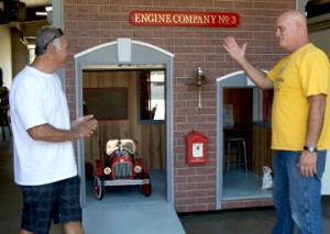 Port Arthur Fire Engineer Mike Perez, left, and Captain Gerrit Achord stand in front of a playhouse built by firefighters for Casas for CASA fundraiser. Mary Meaux/The News