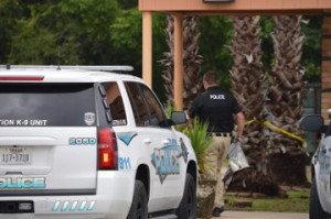 A Port Arthur Police officer walks toward a crime scene behind Royal Furniture in the 4200 block of Gulfway Drive. A man was found shot to death behind the business around 8:30 a.m. Tuesday. Mary Meaux/The News