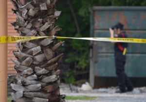 A police department official takes photographs during a murder investigation in the 4200 block of Gulfway Drive on Tuesday.   Mary Meaux/The News 