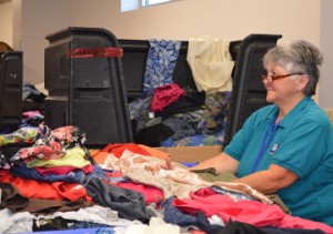 Goodwill employee Margaret Hebert sorts through bins of clothing in the back room at the newly opened Goodwill, 4352 FM 365, on Friday. Mary Meaux/The News