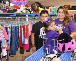 Martha Rodriguez, right, shops with children Mia, 2, and Edward, 12, during the grand opening of Goodwill, 4352 FM 365, on Friday. Mary Meaux/The News