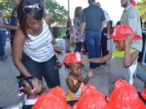 Robert Johnson, 6, right, places a fire hat on his sister Raven Jones, 2, and little sister Holly Oville, 1, and mother Dominque Jones look on during a Port Arthur fire prevention week event at the Robert A. “Bob” Bowers Civic Center on Monday. Mary Meaux/The News