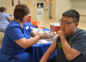 Tanya Bell, a nurse with Port Arthur Health Department, left, administers a flu shot to David Tran during a Port Arthur fire prevention week event at the Robert A. “Bob” Bowers Civic Center on Monday. Mary Meaux/The News