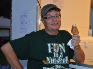 Don Sodman of the Groves Chamber of Commerce and Tourist Center, enjoys a fried cheesecake during the Groves Pecan Festival on Friday. Mary Meaux/The News 