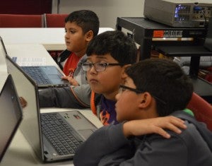 Joan Hermoso, top, Mauricio Dominguez and Nehemias Dominguez navigate the web at the Port Arthur Public Library on Monday. Children were at the library learning how to download books during a program. Mary Meaux/The News 