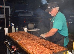 Mickey Hern grills pork-a-bob’s during Groves Pecan Festival on Friday. Mary Meaux/The News 