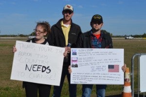 Katelynn Bordages, left, Jeremy Marks and a concerned citizen voice their displeasure with Donald Trump outside Ford Park Saturday. Mary Meaux/The News 