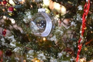 A clear Christmas bulb features a handwritten message for a deceased loved one on the memorial tree at Oak Bluff Memorial Park in Port Neches. Mary Meaux/The News 
