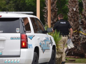 A Port Arthur Police officer walks toward a crime scene behind Royal Furniture in the 4200 block of Gulfway Drive. A man was found shot to death behind the business around 8:30 a.m. Tuesday. Mary Meaux/The News