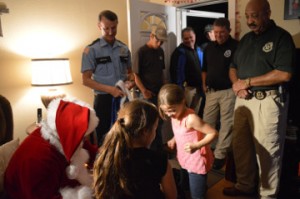 Cadence Clark, center, reacts to Christmas gifts given by members of the Port Arthur Police Department’s Blue Santa Program. Mary Meaux/The News 