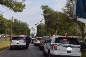 First responders lined the street as Entergy employees remove a live wire from a home after a vehicle crashed through a garage home in the 2800 block of Eighth Street in Port Neches shortly before noon Wednesday. Mary Meaux/The News 