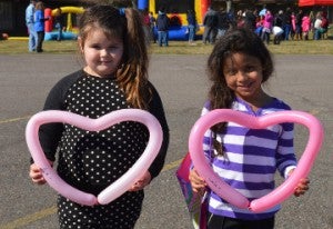 Ava Porter, left, and friend Laila Kaczara, both age 5, pose with the balloon hearts during Easter in January Candy Drop at Memorial Baptist Church on Saturday. Mary Meaux/The News 