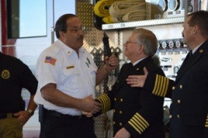 Groves Fire Chief Dale Jackson, left, shakes hands with retiring Port Neches Fire Chief Steve Curran before shaking hands with incoming fire chief Paul Nelson during a ceremony on Friday in Port Neches. Mary Meaux/The News 