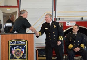 Port Arthur Deputy Chief John Owens, left, shakes hands with Port Neches Fire Chief Steve Curran before shaking hands with incoming fire chief Paul Nelson during a ceremony on Friday in Port Neches. Mary Meaux/The News 