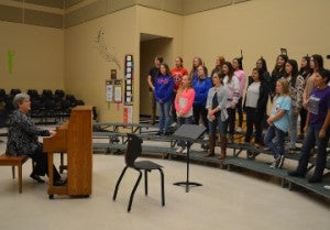 Kathy Hollier, choir director at Groves Middle School, left, works with her students on Wednesday. Mary Meaux/The News