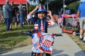 Aaron Jasani, 3, stops for a photo after the Bike and Wagon Parade at Doorknobs Park for the Nederland Fourth of July event on Monday. Mary Meaux/The News