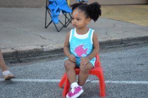 Zoey Young takes a seat as she waits for the annual cavOILcade parade to begin in Port Arthur on Saturday. Mary Meaux/The News