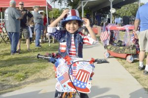 Aaron Jasani, 3, stops for a photo after the Bike and Wagon Parade at Doorknobs Park for the Nederland Fourth of July. (Mary Meaux/The News)