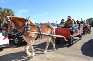 Two horse drawn carriages bring people for a ride during the Museum of the Gulf Coast’s Holiday Extravaganza on Saturday. Mary Meaux/The News