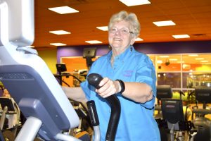 Nellie McCoy, 68, works out on an elliptical machine in the cardio section at Exygon Health and Fitness Club in Nederland. (Lorenzo Salinas/The News)