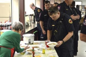 Arthurine Bourke (left) serves members of Port Arthur Fire Department in the PArish Hall of Our Lady of Guadalupe. (Lorenzo Salinas/The News)