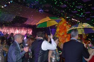Guests shield themselves from the falling confetti by having festively colored umbrellas with them. (Lorenzo Salinas/The News)